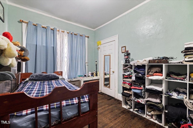 bedroom with ornamental molding and dark hardwood / wood-style flooring