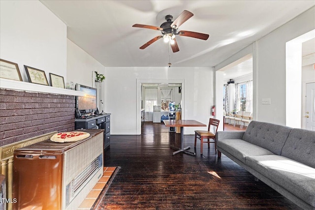 living room featuring ceiling fan and dark hardwood / wood-style floors