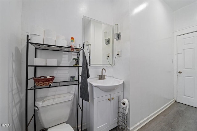 bathroom with wood-type flooring, vanity, and toilet