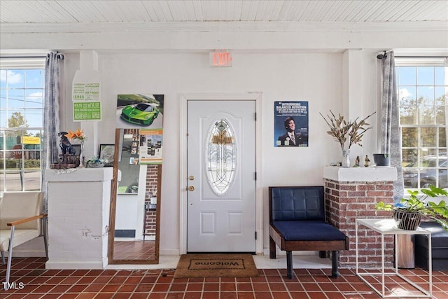 tiled entrance foyer featuring a wealth of natural light, beamed ceiling, and wooden ceiling