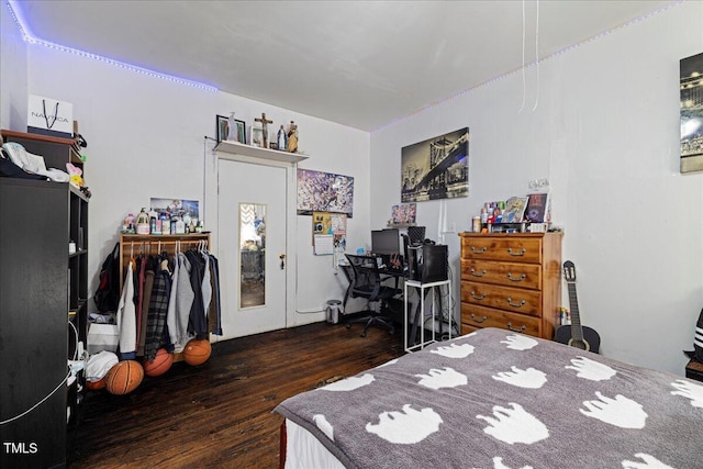 bedroom with dark wood-type flooring and a closet