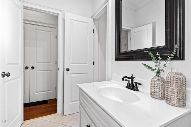 bathroom featuring tile patterned flooring, crown molding, and vanity