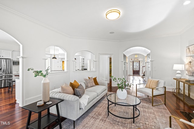 living area with dark wood-type flooring, arched walkways, crown molding, and baseboards