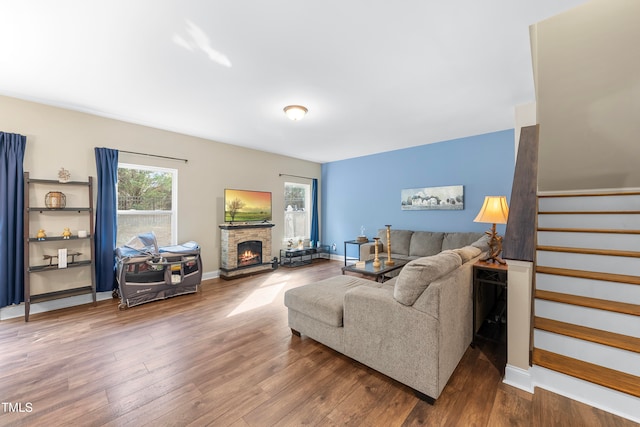 living room featuring hardwood / wood-style flooring and a stone fireplace