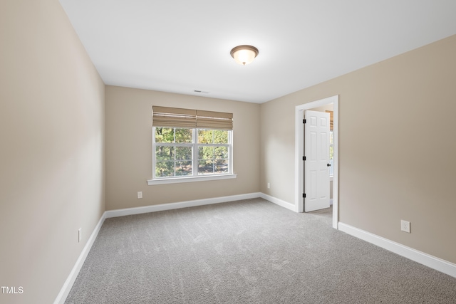 unfurnished room featuring light carpet