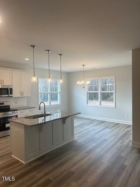 kitchen with white cabinets, stainless steel appliances, a wealth of natural light, and sink