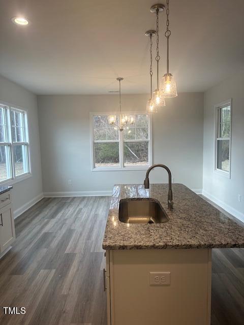 kitchen with pendant lighting, a center island with sink, a wealth of natural light, and sink