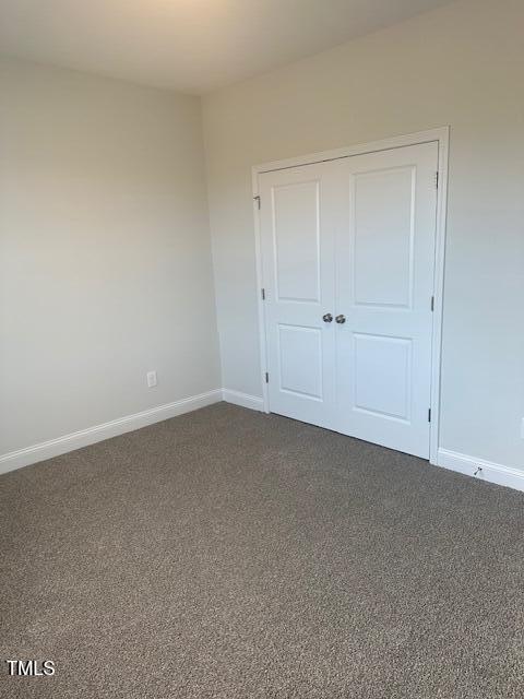 unfurnished bedroom with carpet and a closet