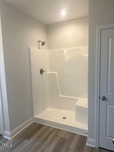 bathroom with wood-type flooring and walk in shower