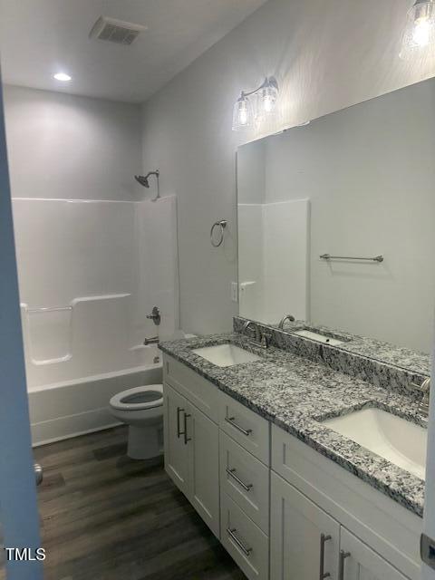 full bathroom featuring shower / bath combination, vanity, toilet, and wood-type flooring