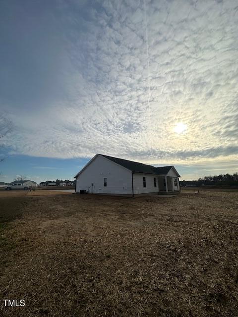 property exterior at dusk featuring a rural view