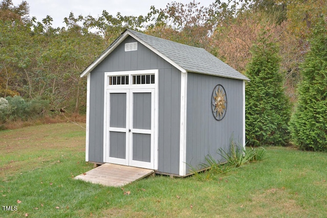 view of outbuilding featuring a lawn