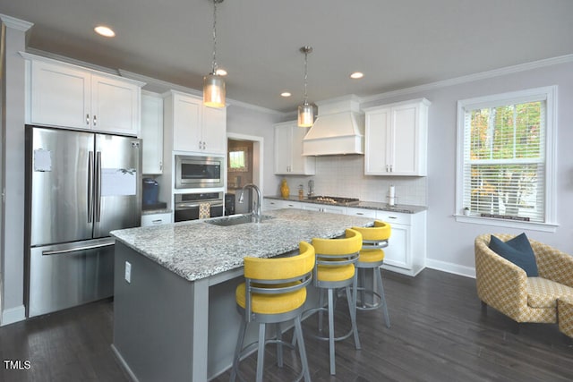 kitchen with stainless steel appliances, white cabinetry, an island with sink, and custom exhaust hood