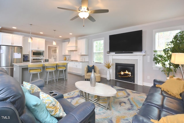 living room featuring ornamental molding, dark wood-type flooring, and ceiling fan