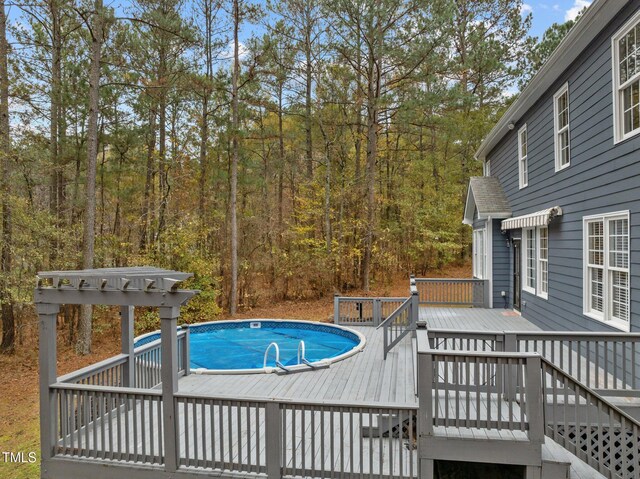 5600 Thornburg Dr, Wake Forest, NC 27587 - outdoor pool featuring a wooden deck and a wooded view