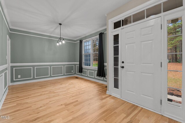 5600 Thornburg Dr, Wake Forest, NC 27587 - foyer with ornamental molding, a decorative wall, a chandelier, light wood finished floors, and wainscoting