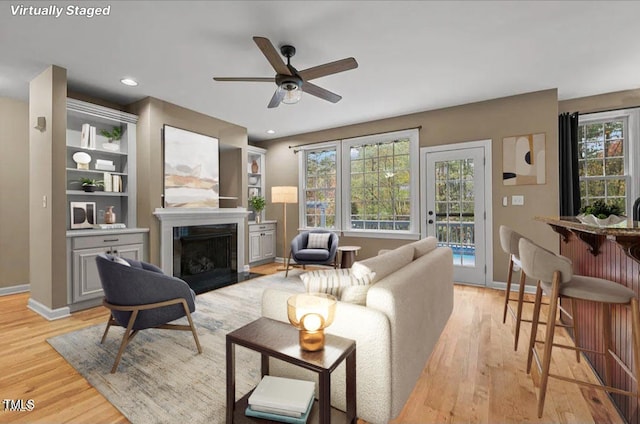 living room featuring light hardwood / wood-style flooring and ceiling fan