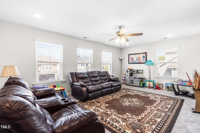 carpeted living room featuring a wealth of natural light and ceiling fan