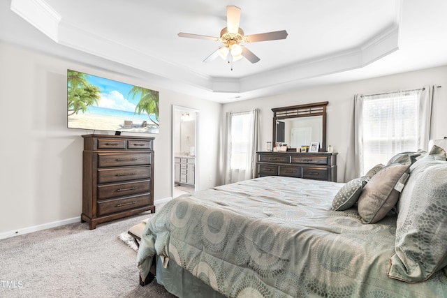 carpeted bedroom featuring multiple windows, ceiling fan, a tray ceiling, and connected bathroom