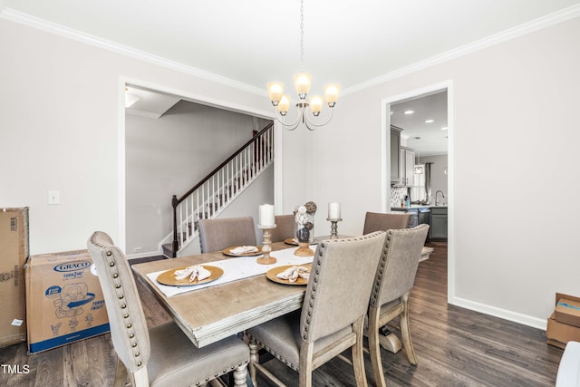 dining area featuring dark wood-type flooring, sink, crown molding, and a notable chandelier