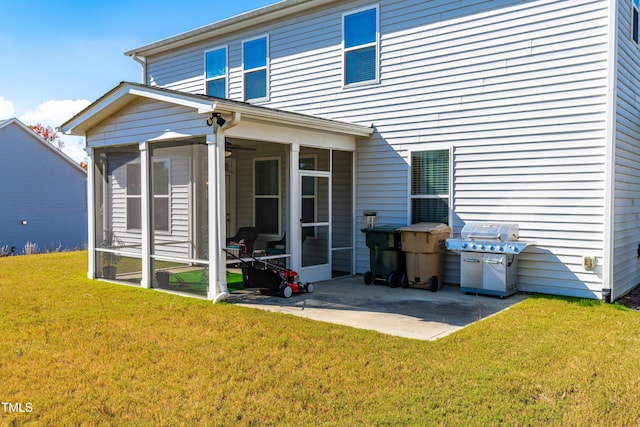 rear view of property featuring a lawn, a patio, and a sunroom