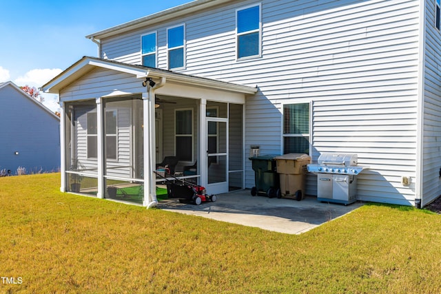 back of property with a sunroom, a patio area, and a lawn