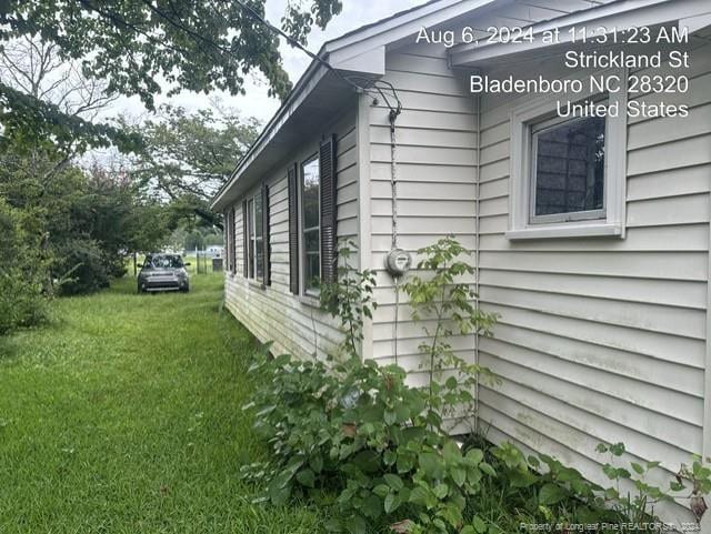 view of side of home with a yard