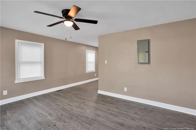 unfurnished room with electric panel, dark hardwood / wood-style floors, and ceiling fan