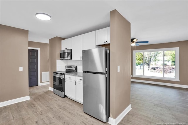 kitchen featuring light wood-type flooring, tasteful backsplash, white cabinetry, and stainless steel appliances