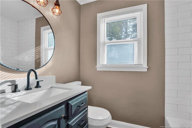 bathroom featuring vanity, toilet, and a tile shower