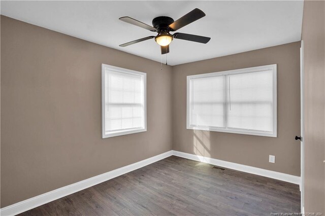 unfurnished room with dark hardwood / wood-style floors and ceiling fan