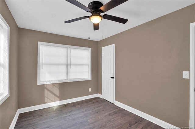 unfurnished room featuring dark hardwood / wood-style floors and ceiling fan