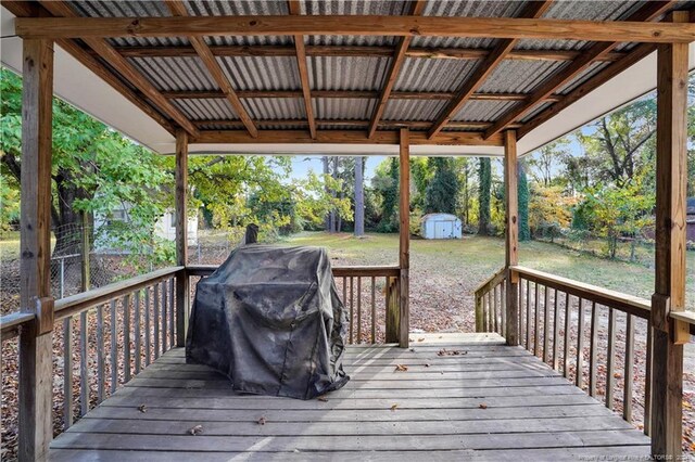 deck with a storage shed and a grill