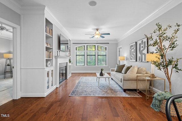 living room with dark wood-type flooring, ceiling fan, and crown molding