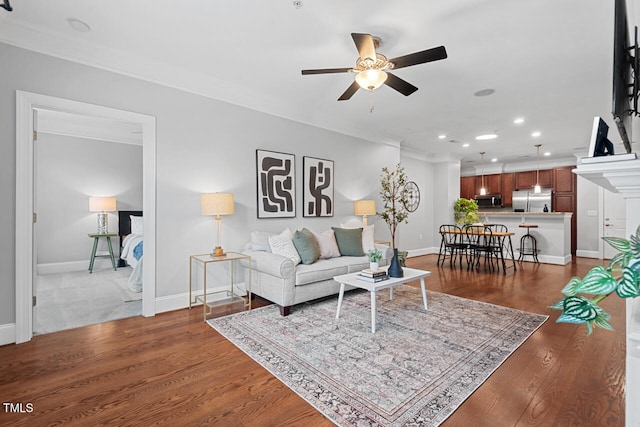 living room with ceiling fan, dark hardwood / wood-style floors, and crown molding