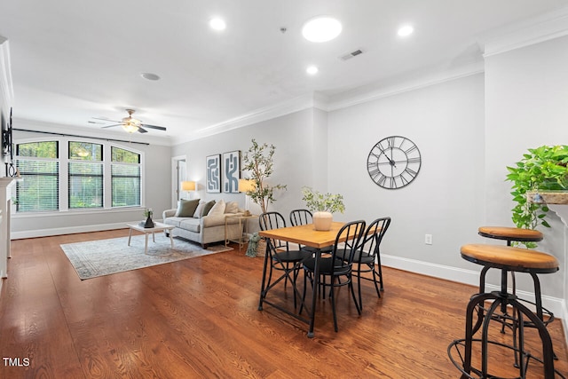 dining space featuring wood-type flooring, ceiling fan, and crown molding