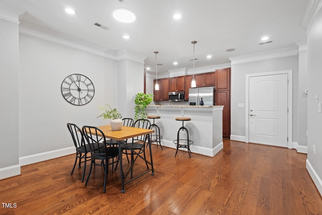 dining space with dark wood-type flooring and crown molding