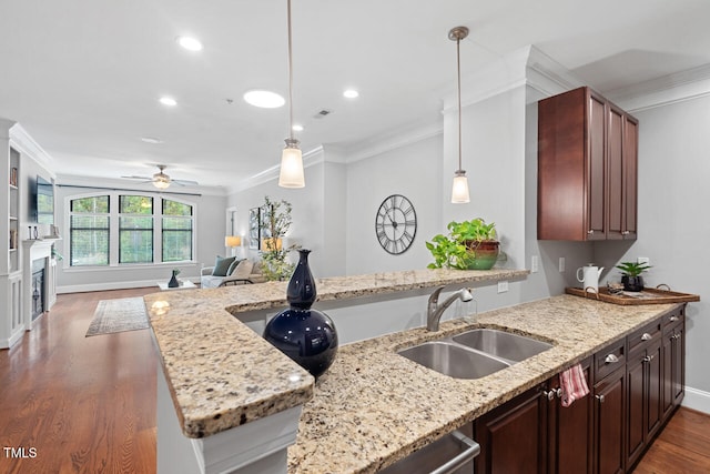 kitchen with kitchen peninsula, crown molding, sink, and dark hardwood / wood-style flooring