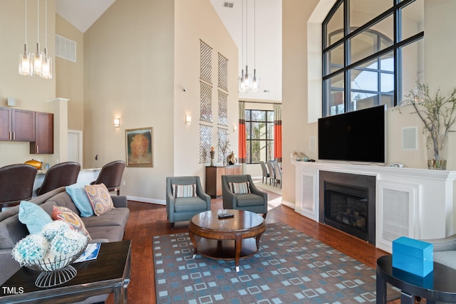 living room with high vaulted ceiling and dark wood-type flooring