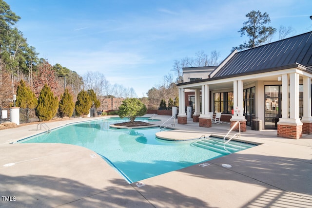 view of pool with a hot tub and a patio