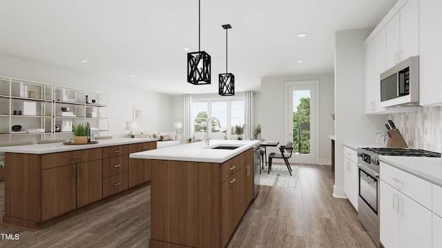 kitchen with white cabinets, a center island with sink, sink, and appliances with stainless steel finishes