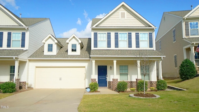 view of front of house featuring covered porch, a garage, and a front lawn