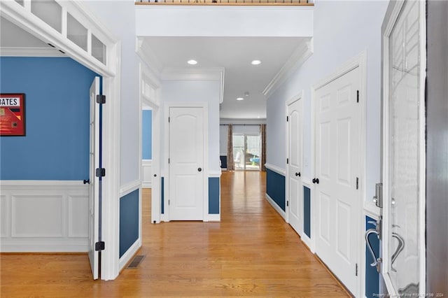 foyer featuring light hardwood / wood-style floors and crown molding