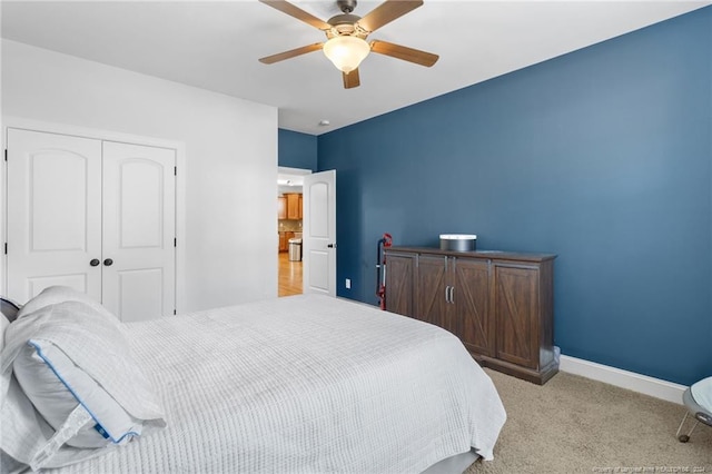 bedroom with light carpet, ceiling fan, and a closet