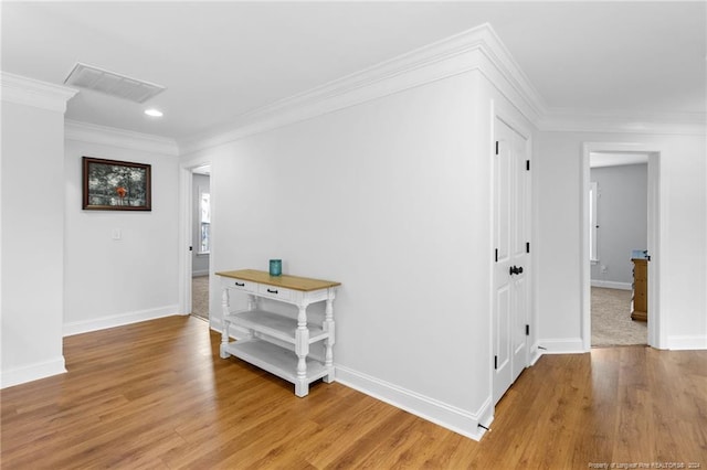 corridor featuring crown molding and light hardwood / wood-style flooring