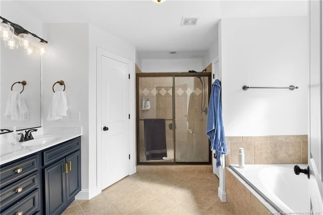 bathroom featuring tile patterned floors, vanity, and shower with separate bathtub