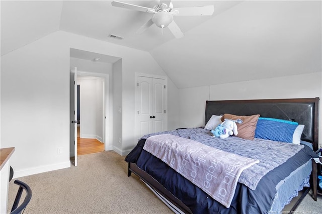 carpeted bedroom with vaulted ceiling and ceiling fan