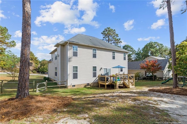 rear view of property featuring a deck and a yard