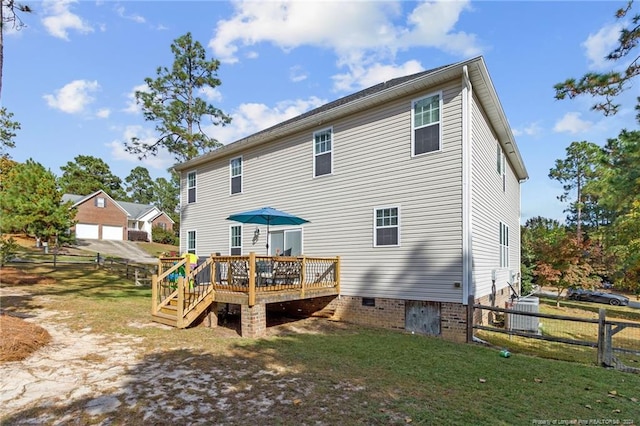 back of house with a garage, a lawn, central AC, and a deck