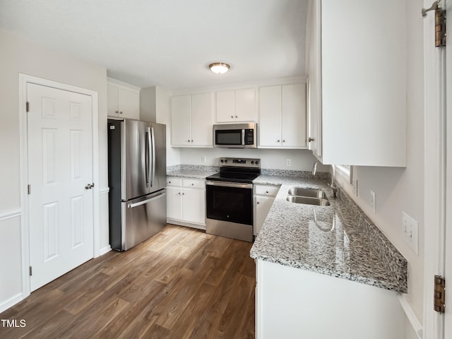 kitchen with dark wood-type flooring, appliances with stainless steel finishes, sink, and white cabinets